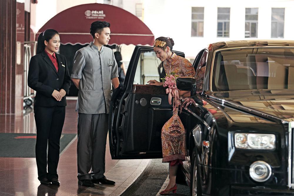 China Hotel Guangzhou - Subway Direct To Pazhou Exhibition Center, Free Shuttle During Canton Fair & Exhibitor Registration Counter Екстер'єр фото A guest is helped out of a car at the entrance of a hotel